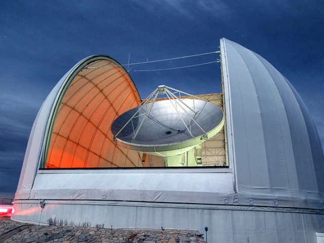 At night, the open dome reveals the dish of the Arizona Radio Observatory's 12-meter Telescope on Kitt Peak 