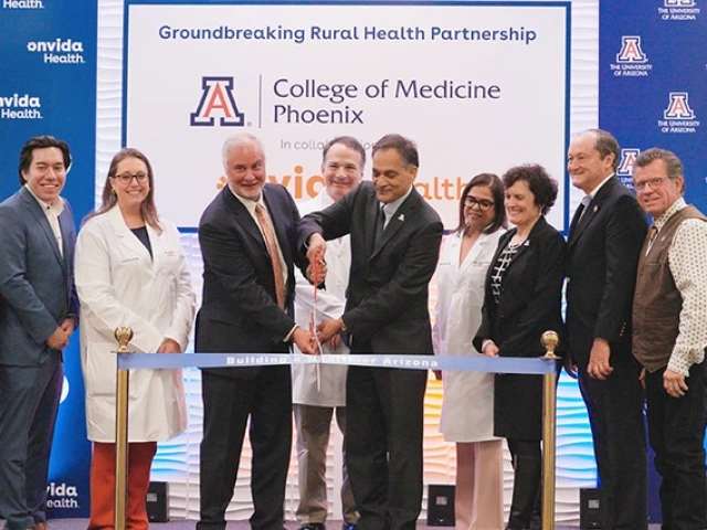 Several men and women at a ribbon cutting ceremony