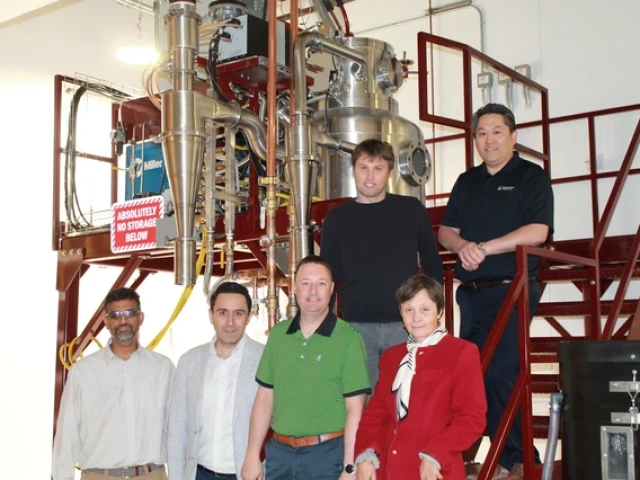 The Mach-X research team posing for a photo in their lab with scientific machinery behind them